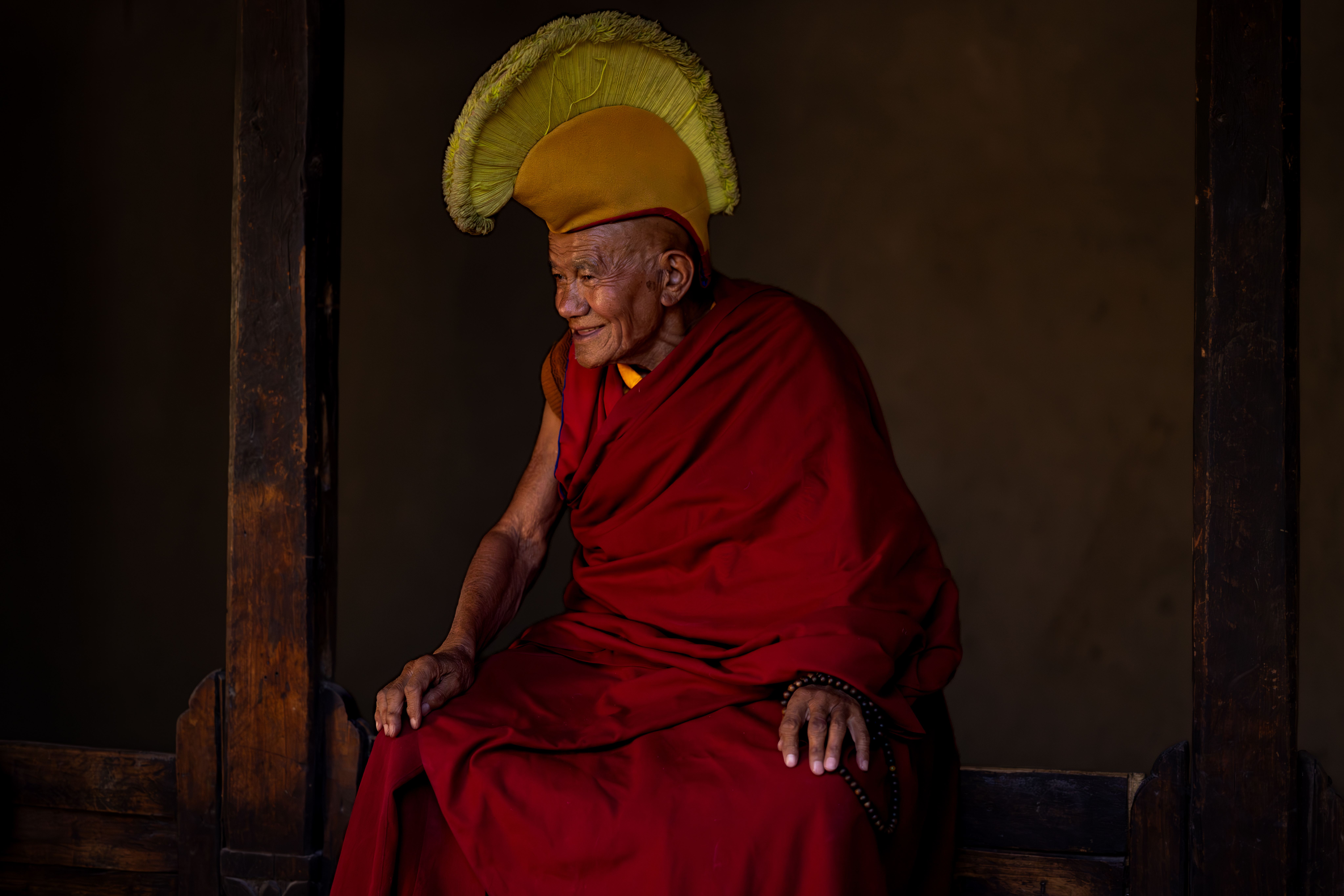 Elderly Buddhist monk in Ladakh monastery captured during cultural photography tour